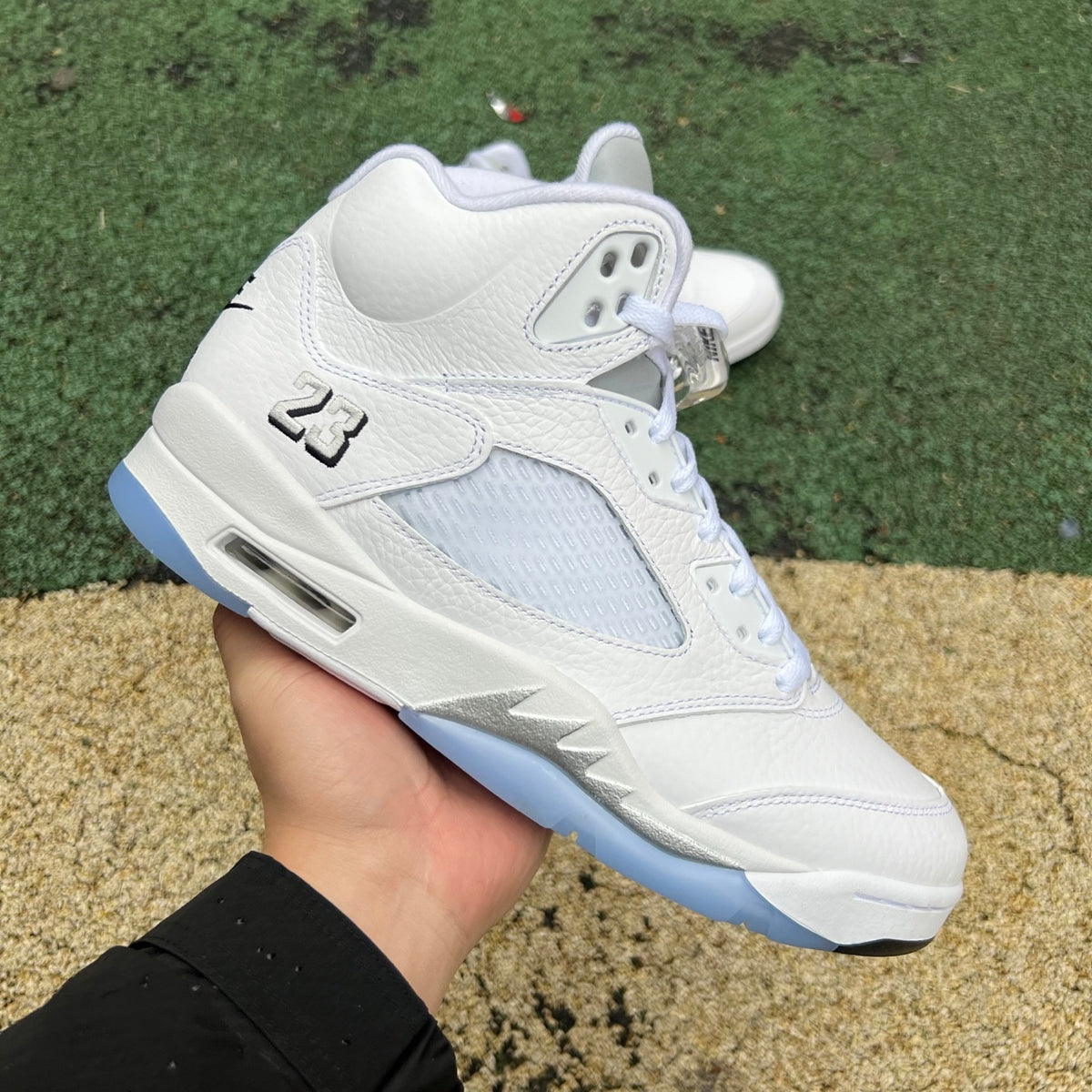 Nike Air Jordan 5 Retro White Metallic sneakers with black accents, detailed close-up of the classic basketball shoe design.