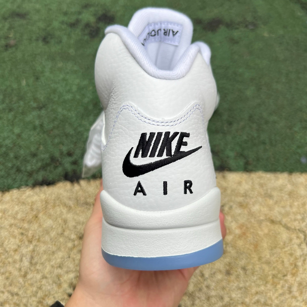 Nike Air Jordan 5 Retro White Metallic sneakers, front view showing white leather upper and metallic silver accents.