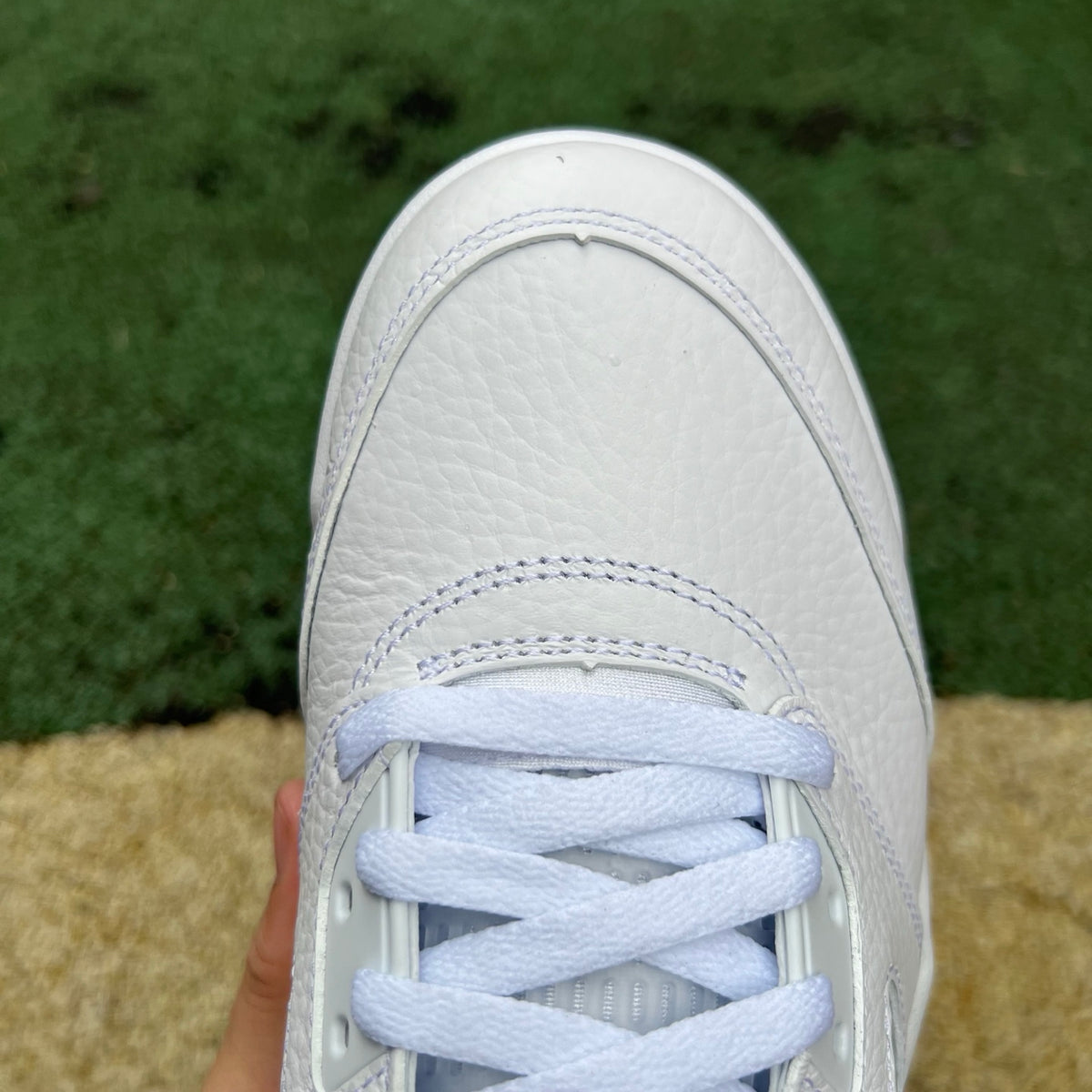 White Nike Air Jordan 5 Retro sneakers with metallic accents, front view showing the iconic design and details.