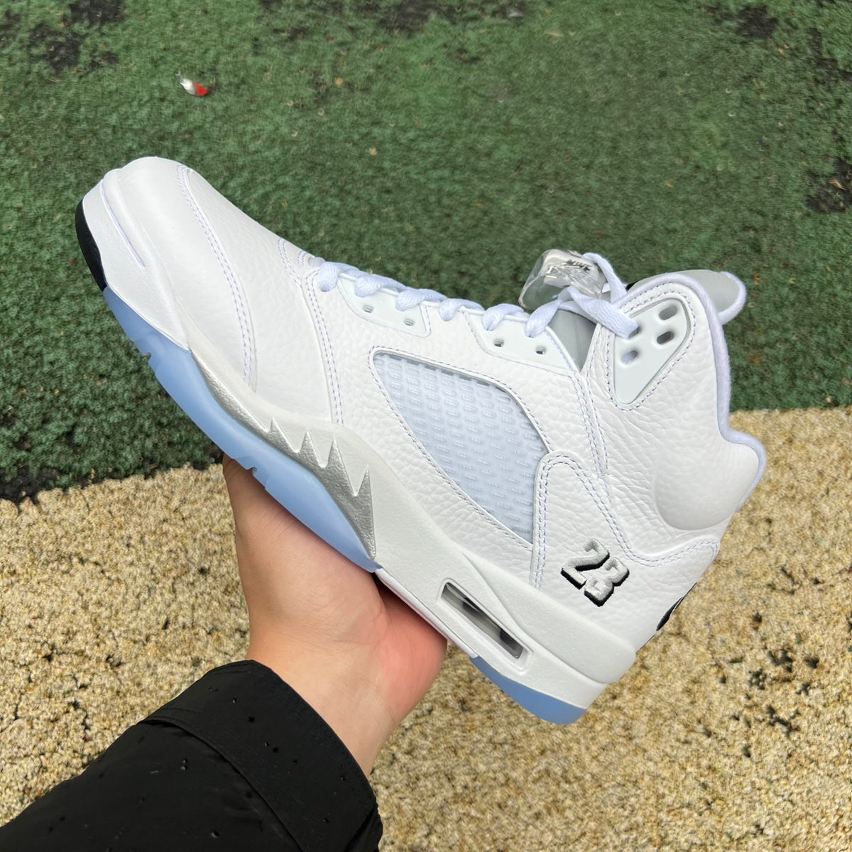 Nike Air Jordan 5 Retro White Metallic sneakers in close-up view showing the white and metallic silver design details.