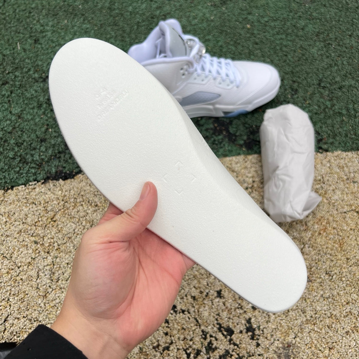 White Nike Air Jordan 5 Retro sneakers with metallic accents, showcasing the classic design and high-quality materials.