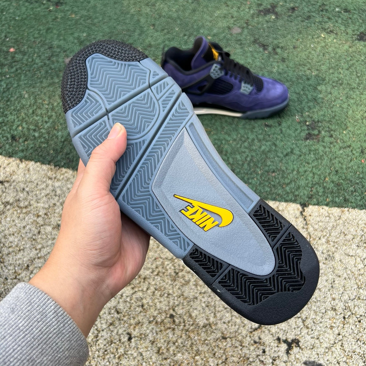 Nike Air Jordan 4 Retro Lakers sneakers in purple and yellow with white accents, showcasing the iconic basketball shoe design.