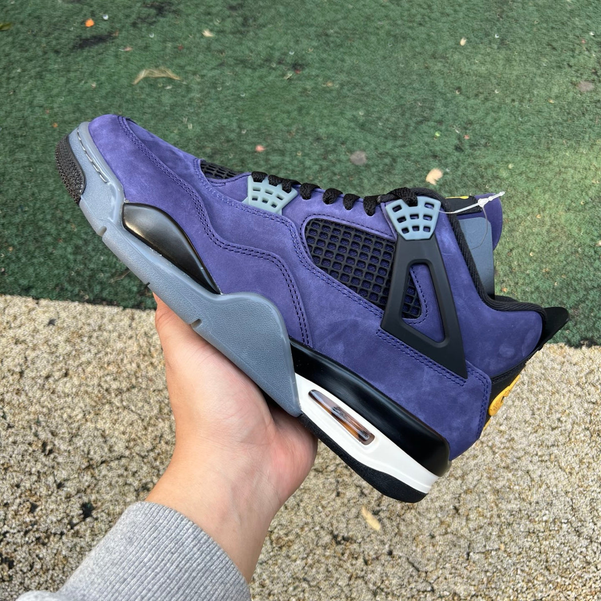 Nike Air Jordan 4 Retro Lakers sneakers in purple and gold with white accents, showcasing the iconic basketball shoe design.