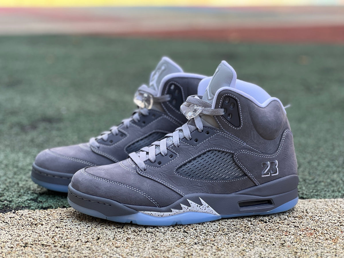 Nike Air Jordan 5 Retro Wolf Grey sneakers, featuring a grey and black design with visible air cushions and classic Jordan branding.