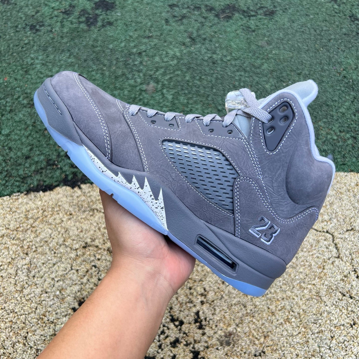 Nike Air Jordan 5 Retro Wolf Grey sneakers with grey suede and mesh upper, featuring black accents and a translucent sole.