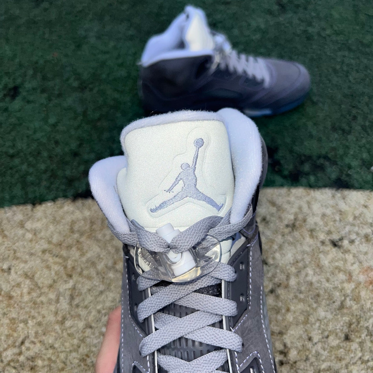 Nike Air Jordan 5 Retro Wolf Grey sneakers featuring grey suede and plastic accents, displayed on a white background.