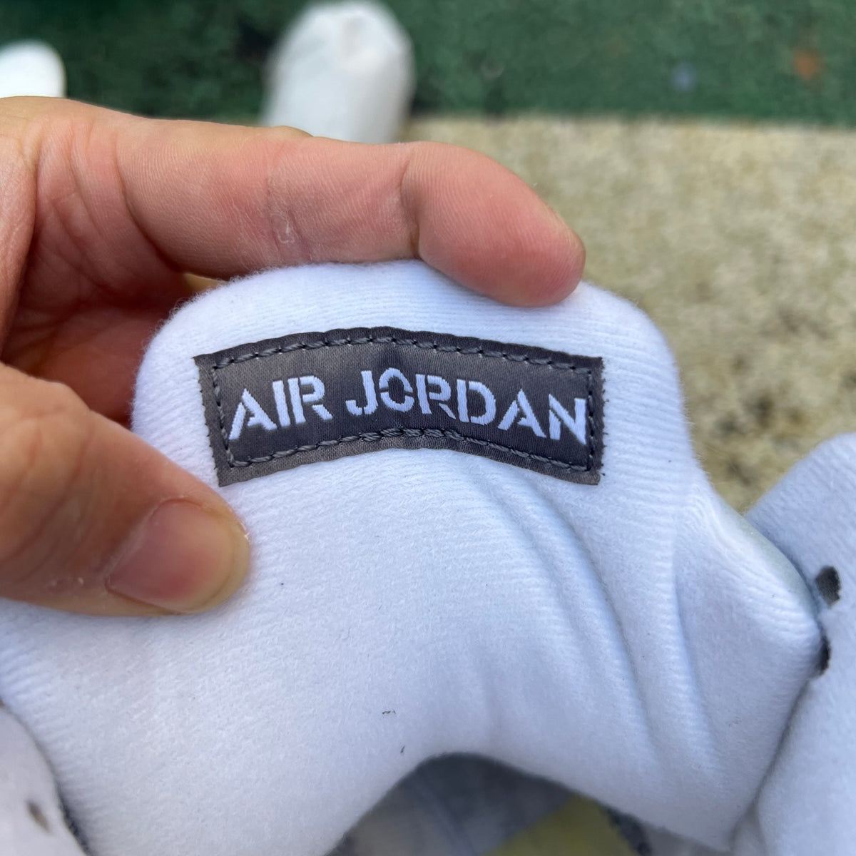 Nike Air Jordan 5 Retro Wolf Grey sneakers, featuring grey suede and white accents, displayed in a close-up shot.