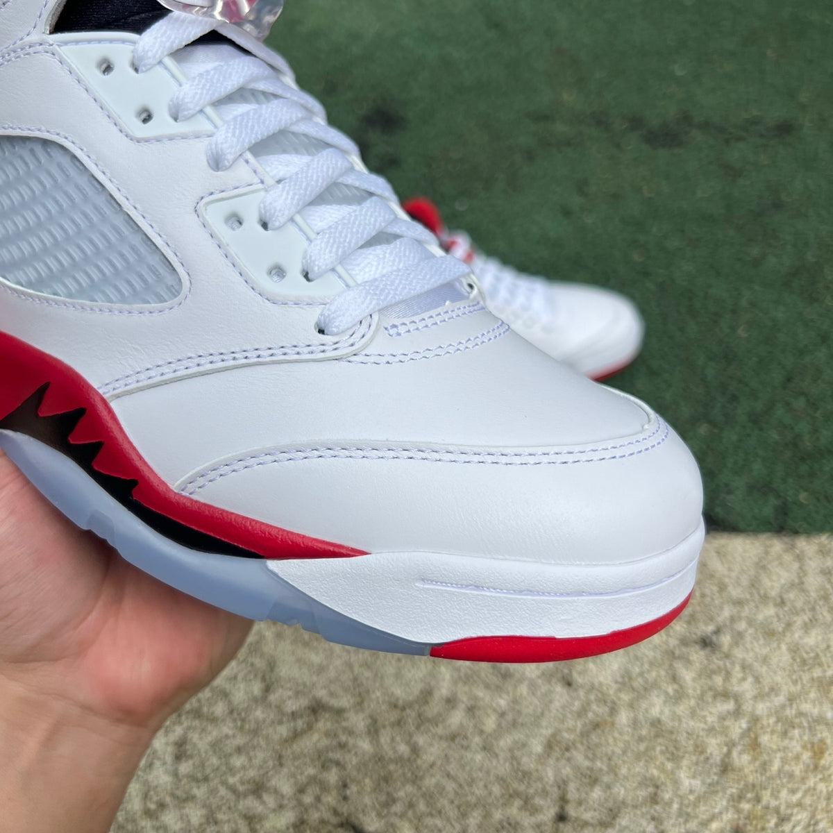 Nike Air Jordan 5 Retro Fire Red and Black sneakers with a prominent tongue, detailed view from the side.