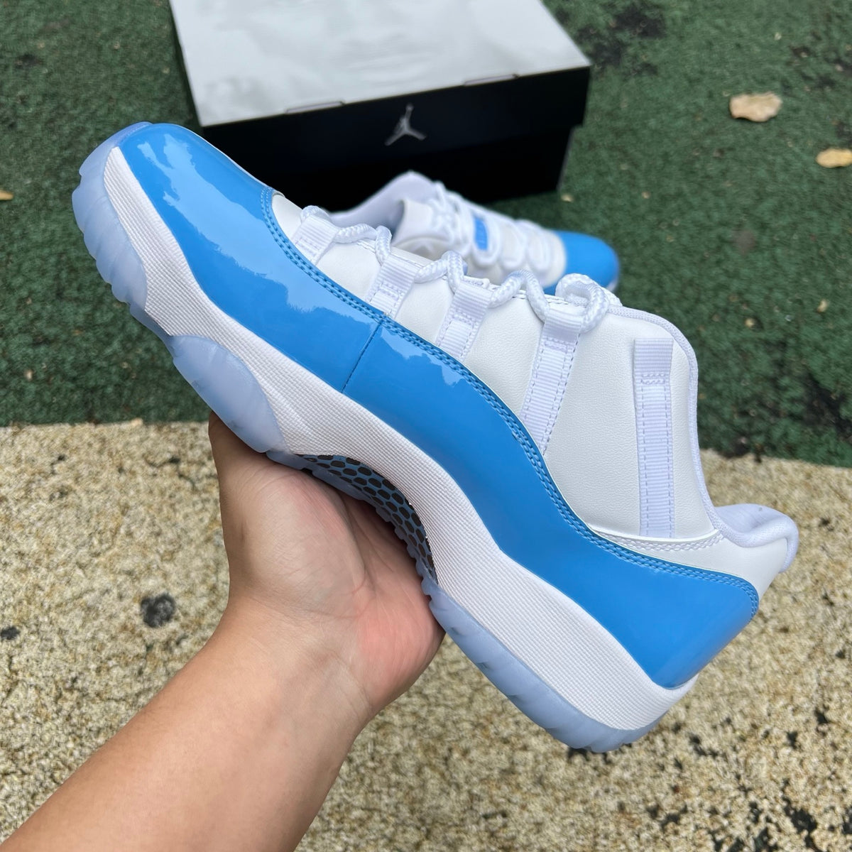 Nike Air Jordan 11 Retro Low University Blue sneakers shown from side angle, featuring blue patent leather and white midsole.