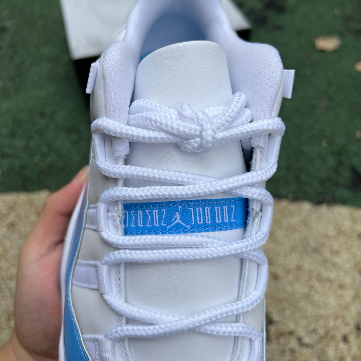 Nike Air Jordan 11 Retro Low University Blue sneakers, featuring blue patent leather and white accents, on a white background.