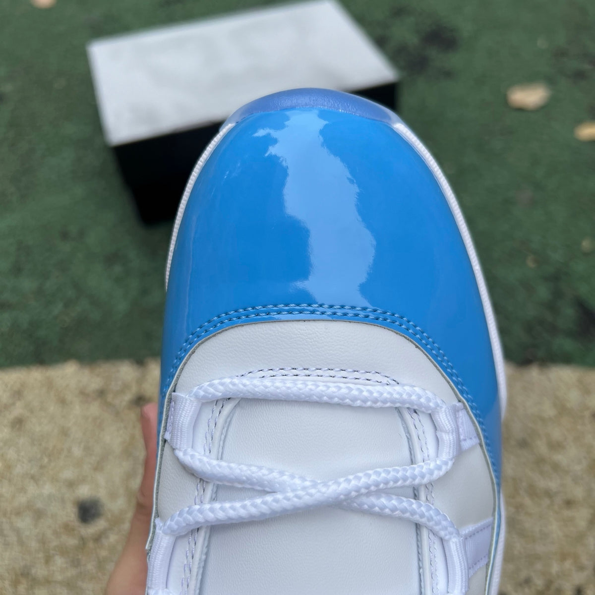 Nike Air Jordan 11 Retro Low University Blue sneakers in white and blue with patent leather detailing, casual athletic style.