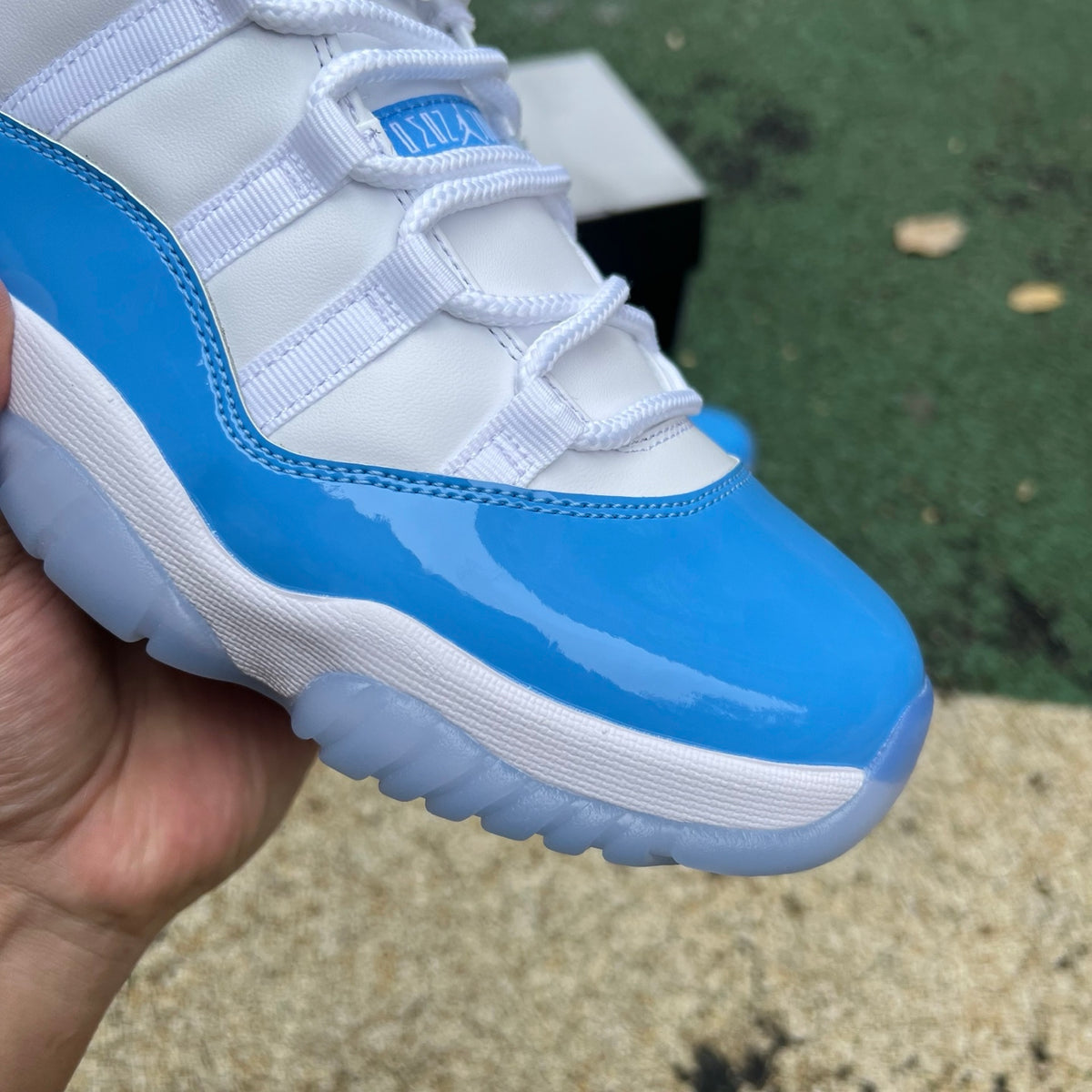 Nike Air Jordan 11 Retro Low University Blue sneakers in white and blue with patent leather details and Nike branding.