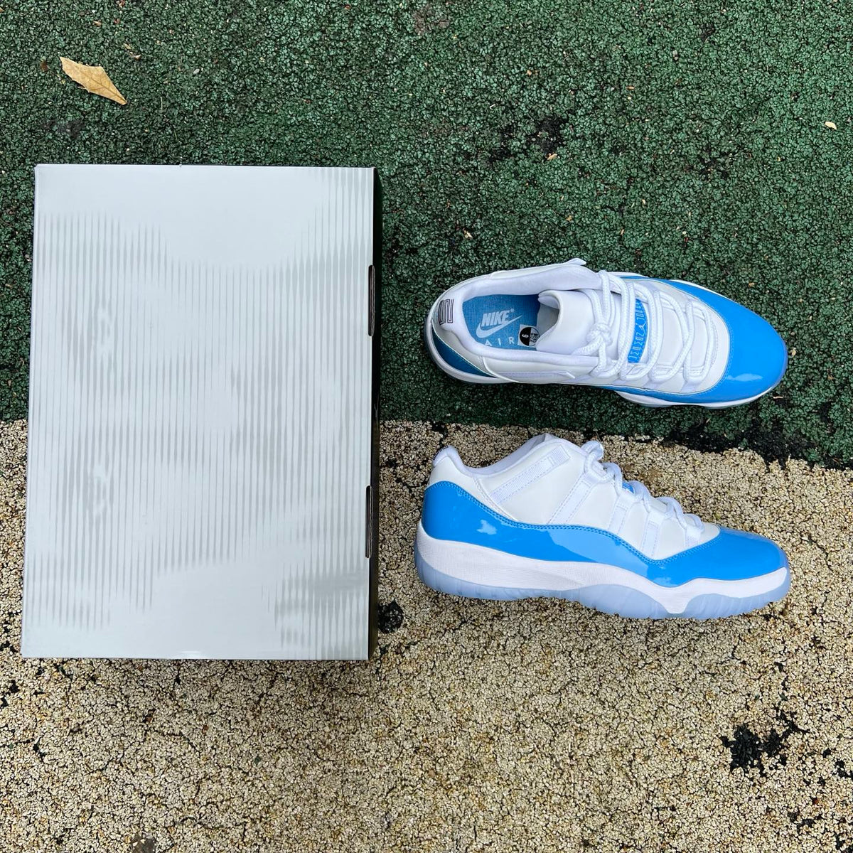 Nike Air Jordan 11 Retro Low University Blue sneakers in white and blue with patent leather details.