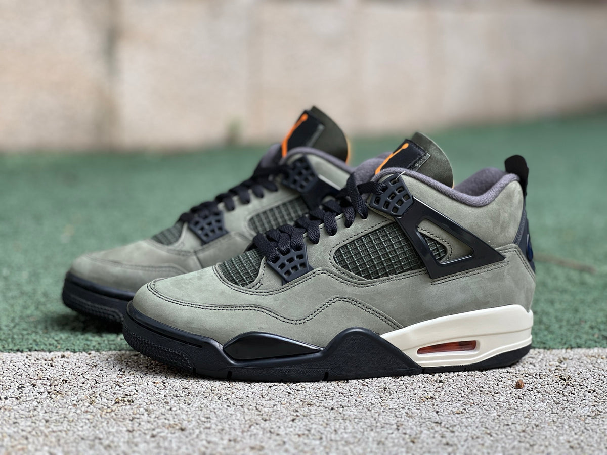 Nike Air Jordan 4 Retro OG SP Undefeated sneakers in white and black with red accents, featuring a classic basketball shoe design.