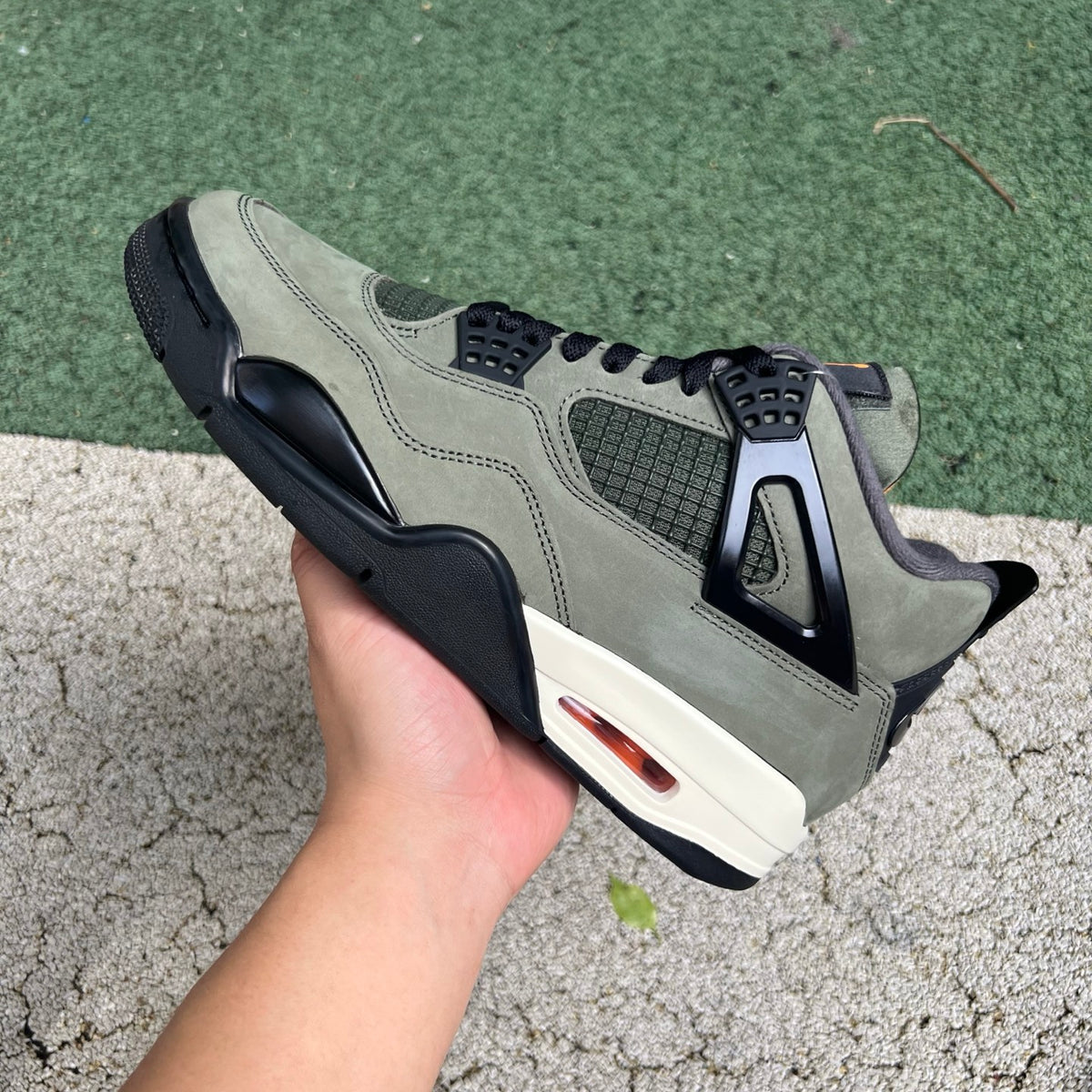 Close-up of Nike Air Jordan 4 Retro OG SP Undefeated sneakers in black and white with suede and leather details.