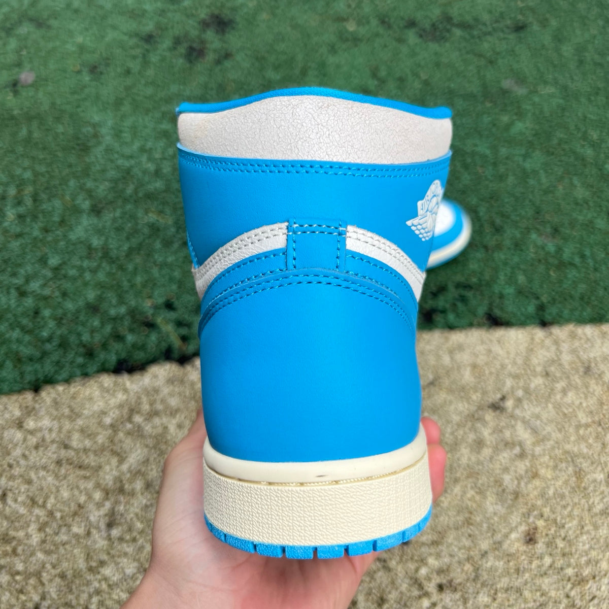 Nike Air Jordan 1 Retro High OG UNC Reimagined sneakers in white and blue leather with black accents, close-up view.