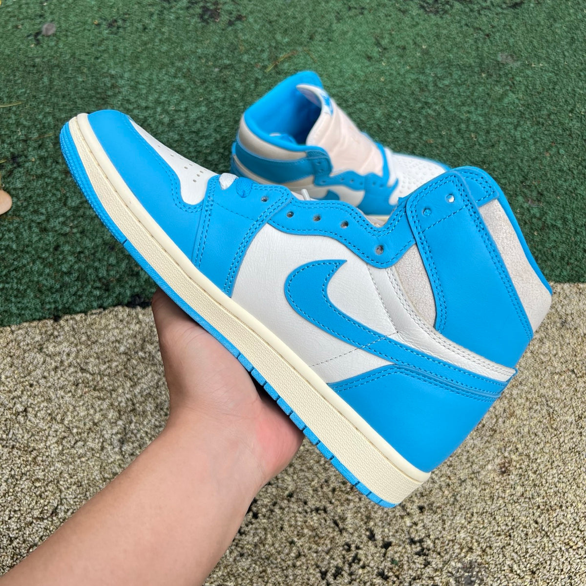 Nike Air Jordan 1 Retro High OG UNC Reimagined sneakers in blue and white leather with Nike swoosh and high-top design.