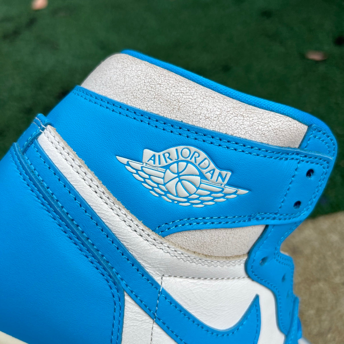 Nike Air Jordan 1 Retro High OG UNC Reimagined sneakers in white and blue with Nike swoosh and high-top design.