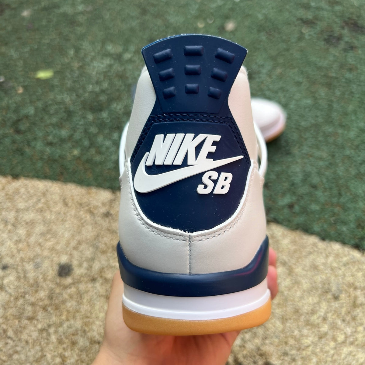 Nike Air Jordan 4 Retro SB sneakers in navy blue with white and gray accents, featuring a classic basketball shoe design.