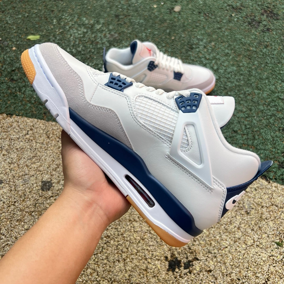 Nike Air Jordan 4 Retro SB sneakers in navy with white accents, featuring classic design and branding details.