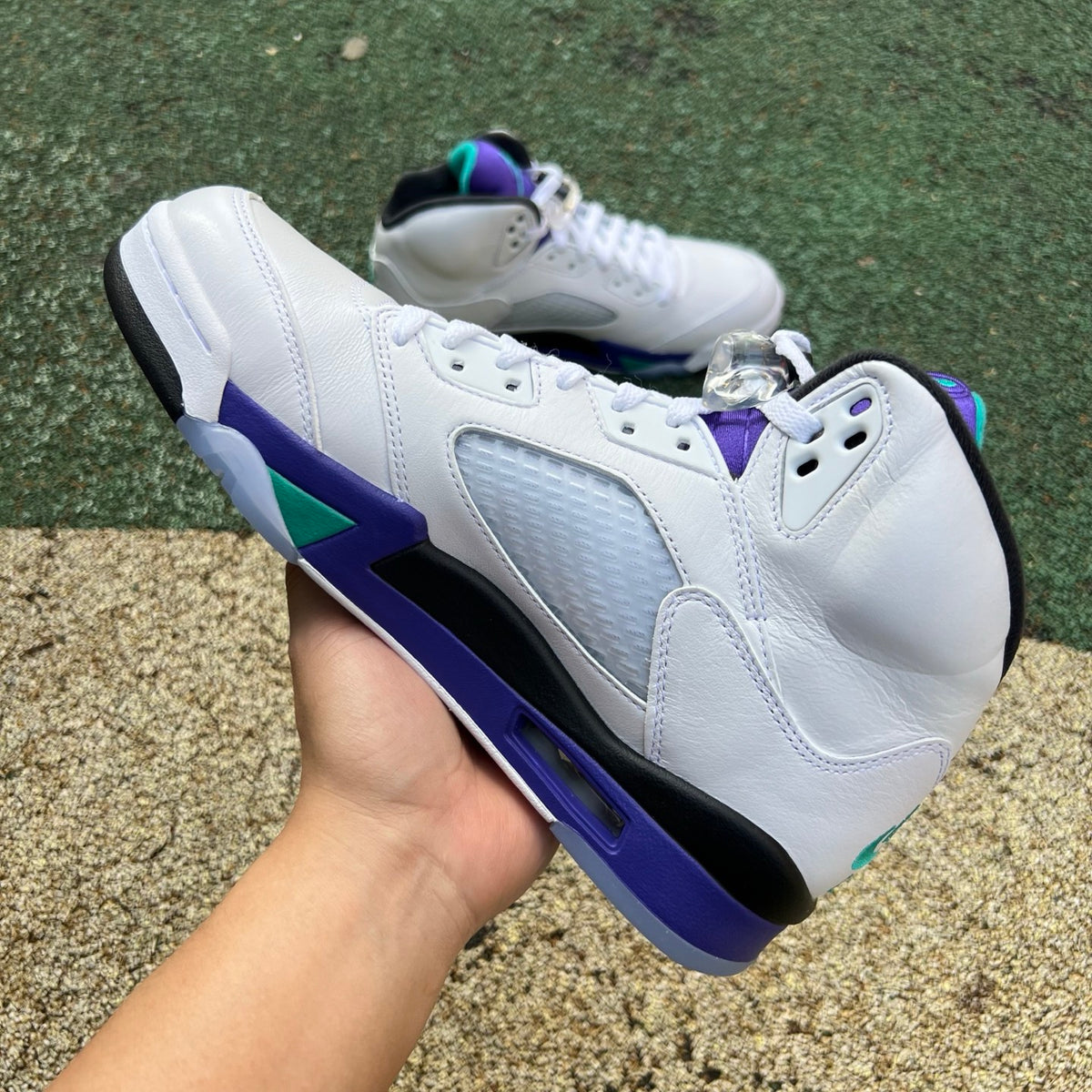 Nike Air Jordan 5 Retro Grape sneakers in white with purple and teal accents, front view highlighting design details.