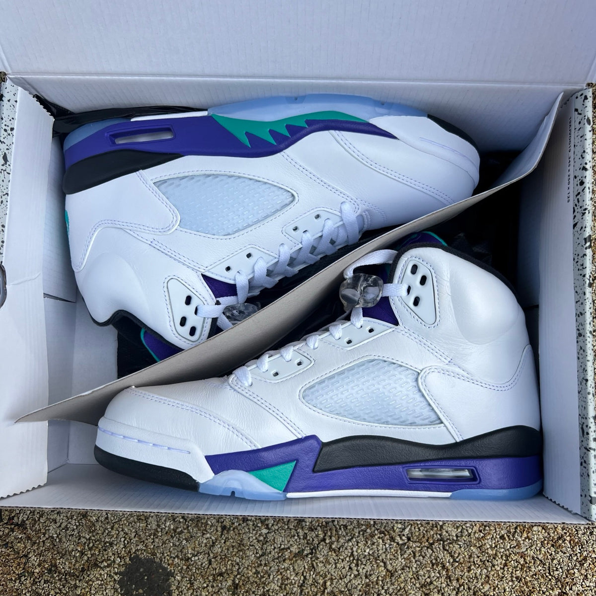 Nike Air Jordan 5 Retro Grape sneakers in white, purple, and teal with a classic design and visible Jordan branding.