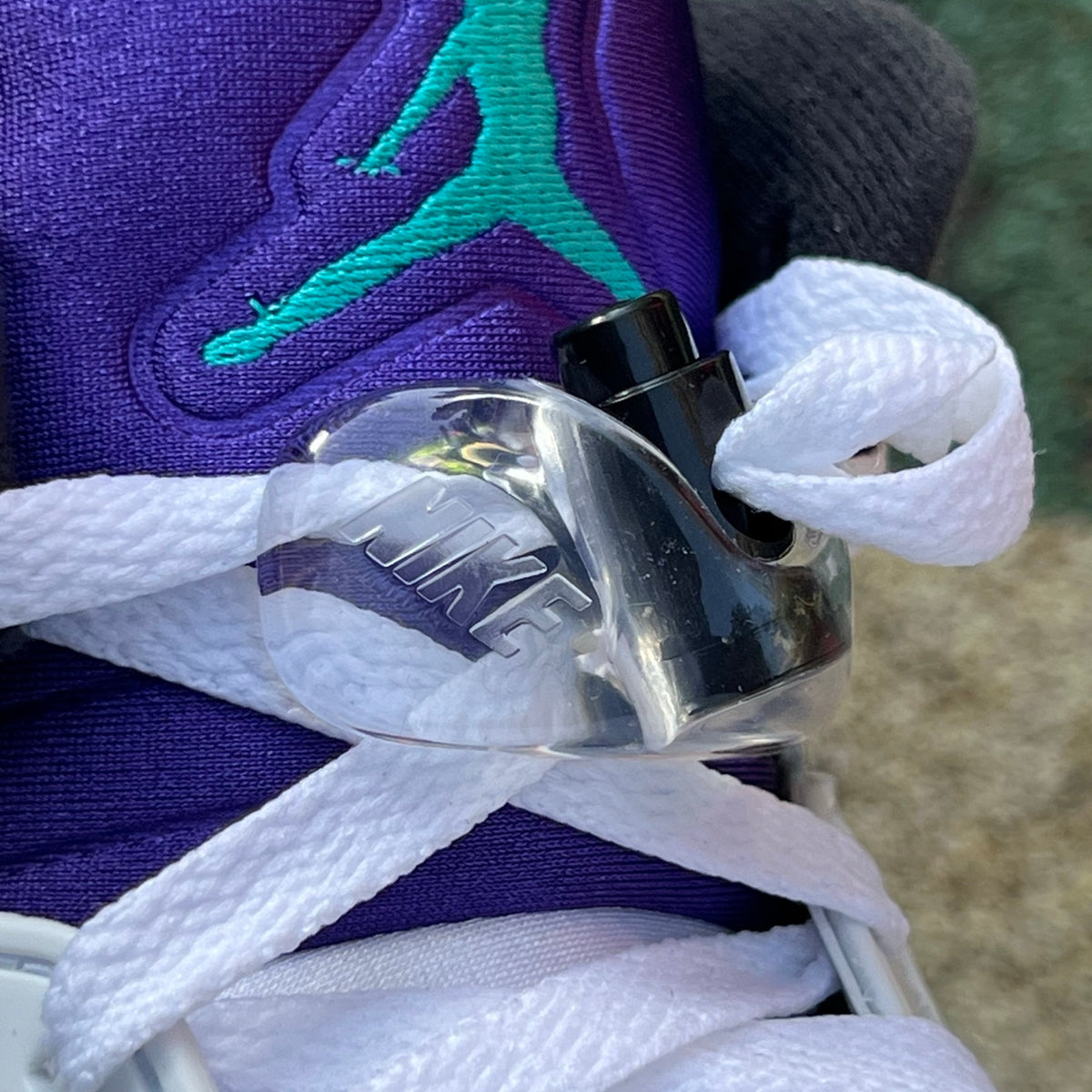 Nike Air Jordan 5 Retro Grape sneakers in white, purple, and blue with black accents, close-up view of the iconic design and details.