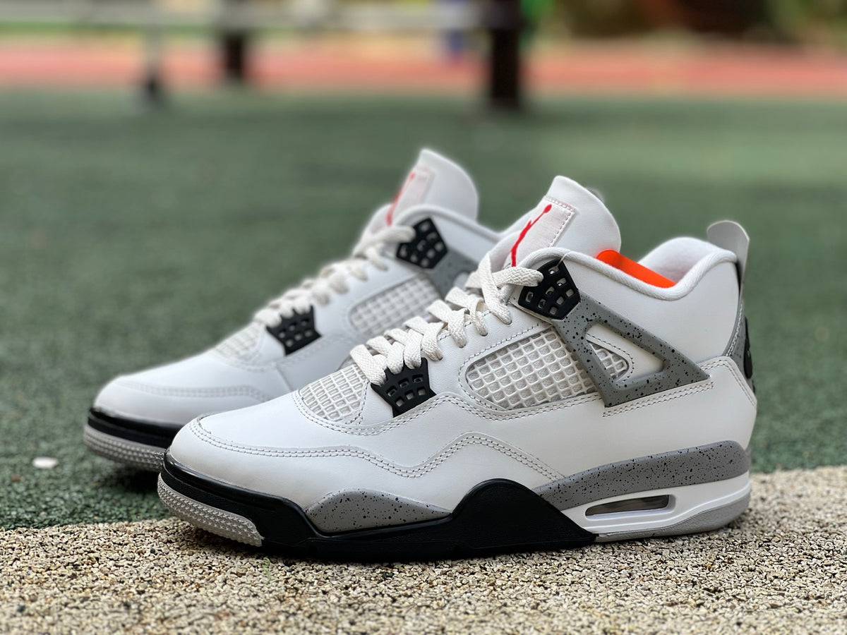 Nike Air Jordan 4 Retro White Cement sneakers in white with black accents, showcasing the classic design and premium materials.