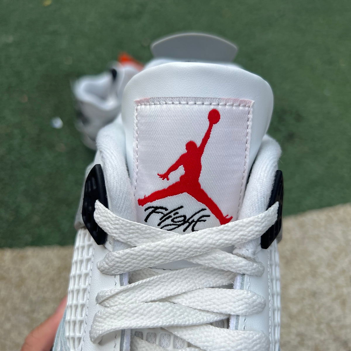 Nike Air Jordan 4 Retro White Cement sneakers with white and grey colorway, featuring signature design details.
