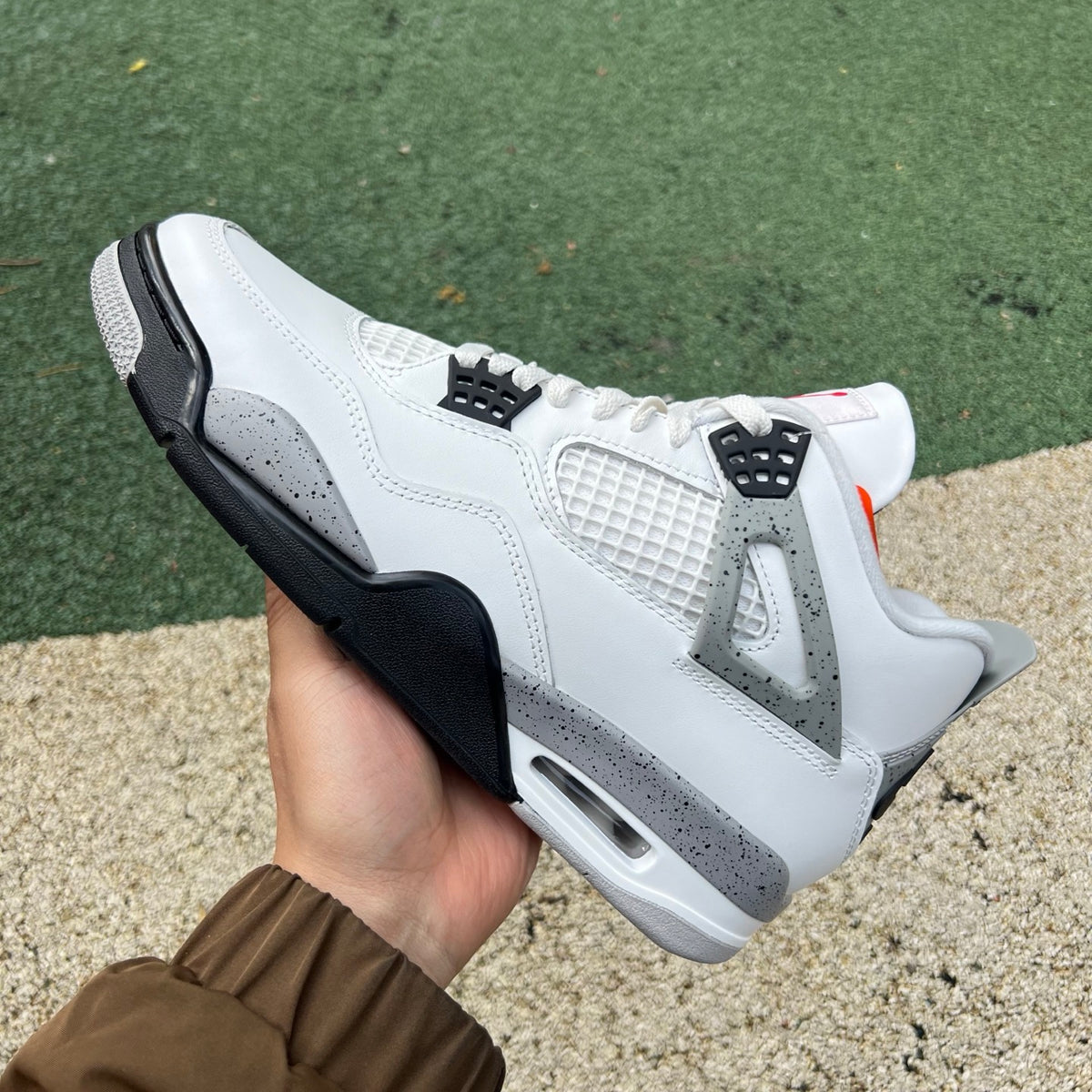Nike Air Jordan 4 Retro White Cement sneakers in white with grey accents, featuring classic design and premium materials.