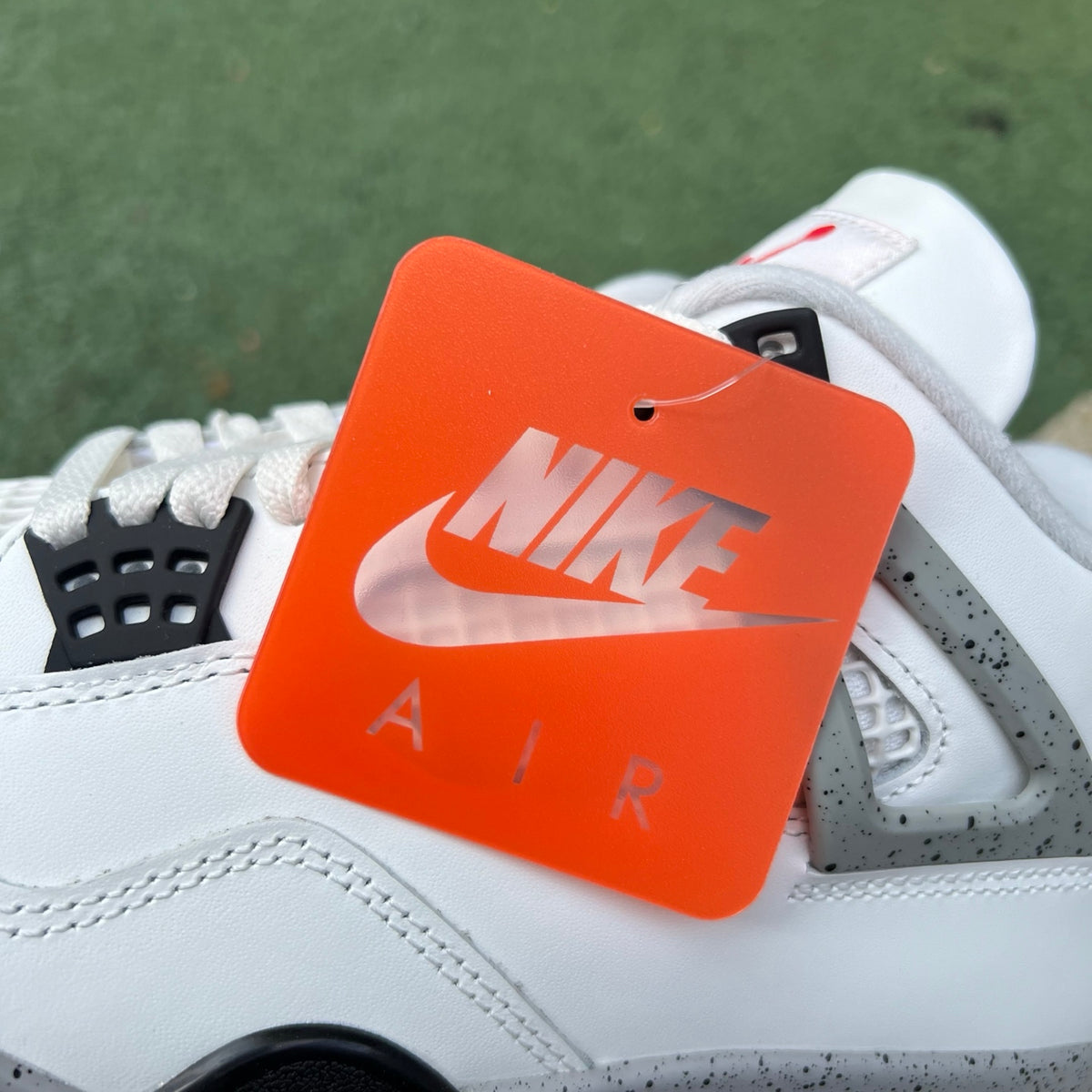 Nike Air Jordan 4 Retro White Cement sneakers with white and gray colorway, featuring signature design details.
