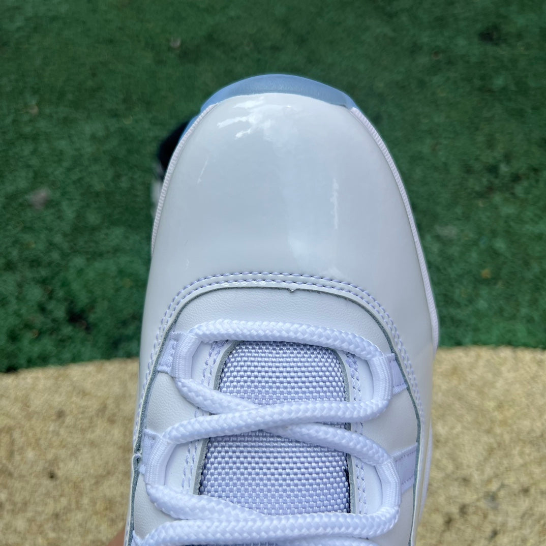 Nike Air Jordan 11 Retro Legend Blue sneakers featuring shiny patent leather, white mesh upper, and icy blue translucent outsole.