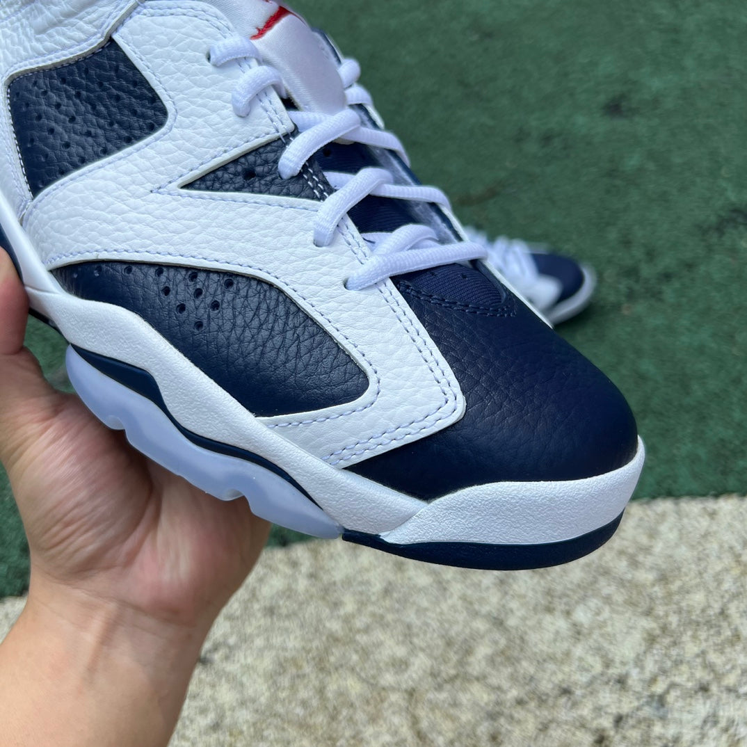 Nike Air Jordan 6 Retro Olympic sneakers in blue, white, and gold with Nike and Jordan branding, showcased from side angle.