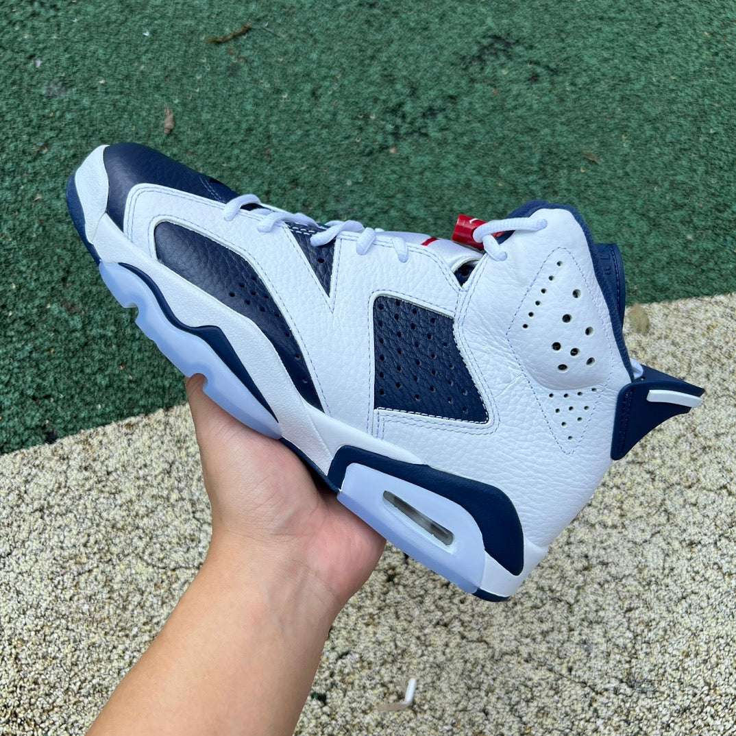 Nike Air Jordan 6 Retro Olympic sneakers in blue, white, and gold with sporty design and signature Jordan branding.