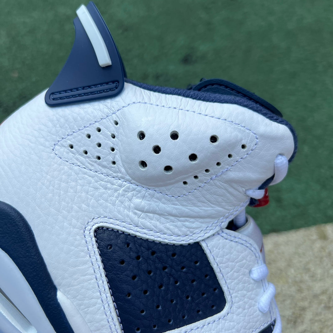 Nike Air Jordan 6 Retro Olympic sneakers in white, blue, and red with a sporty design and iconic Jumpman logo.