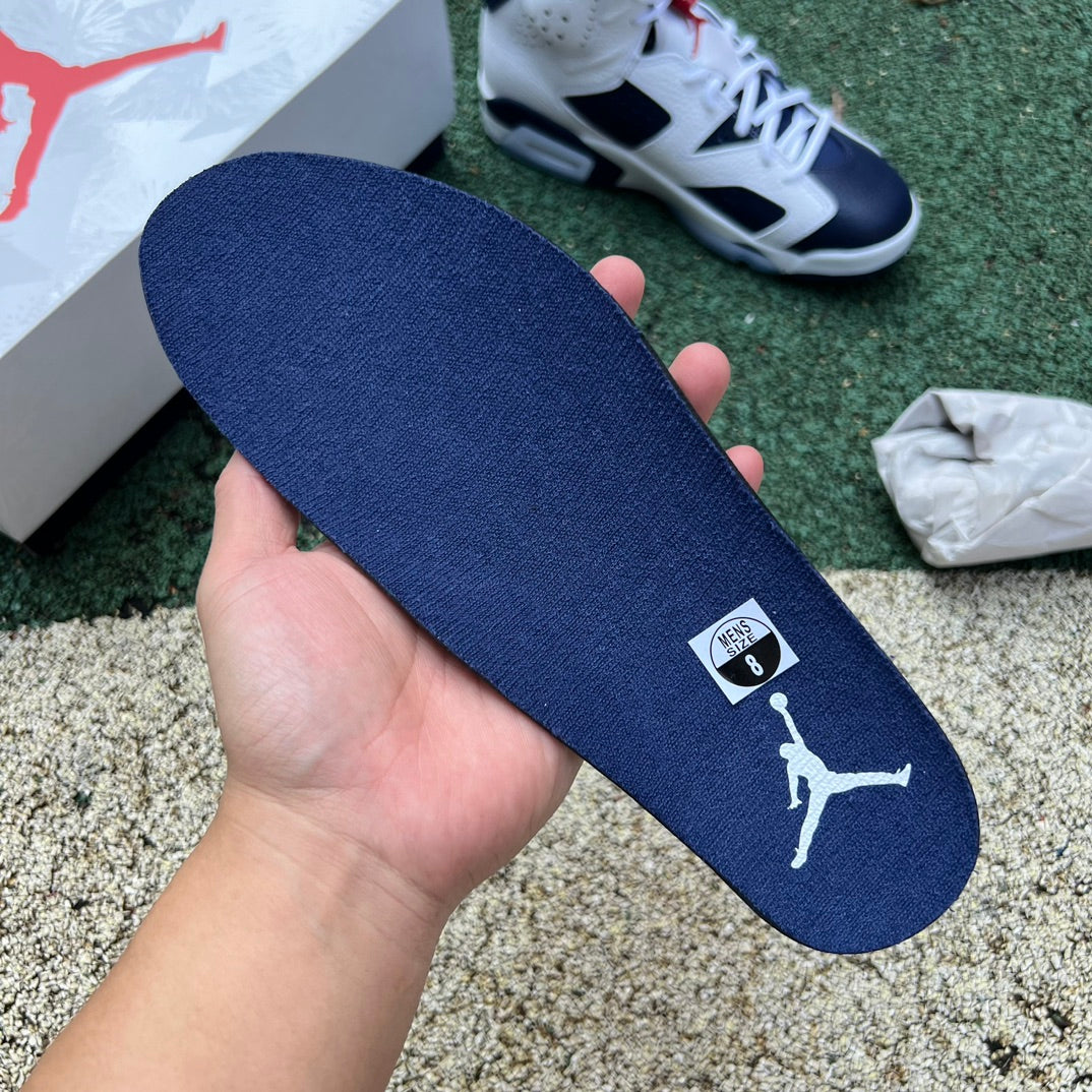 Nike Air Jordan 6 Retro Olympic sneakers in white, blue, and gold, featuring Nike x Jordan branding and classic design details.