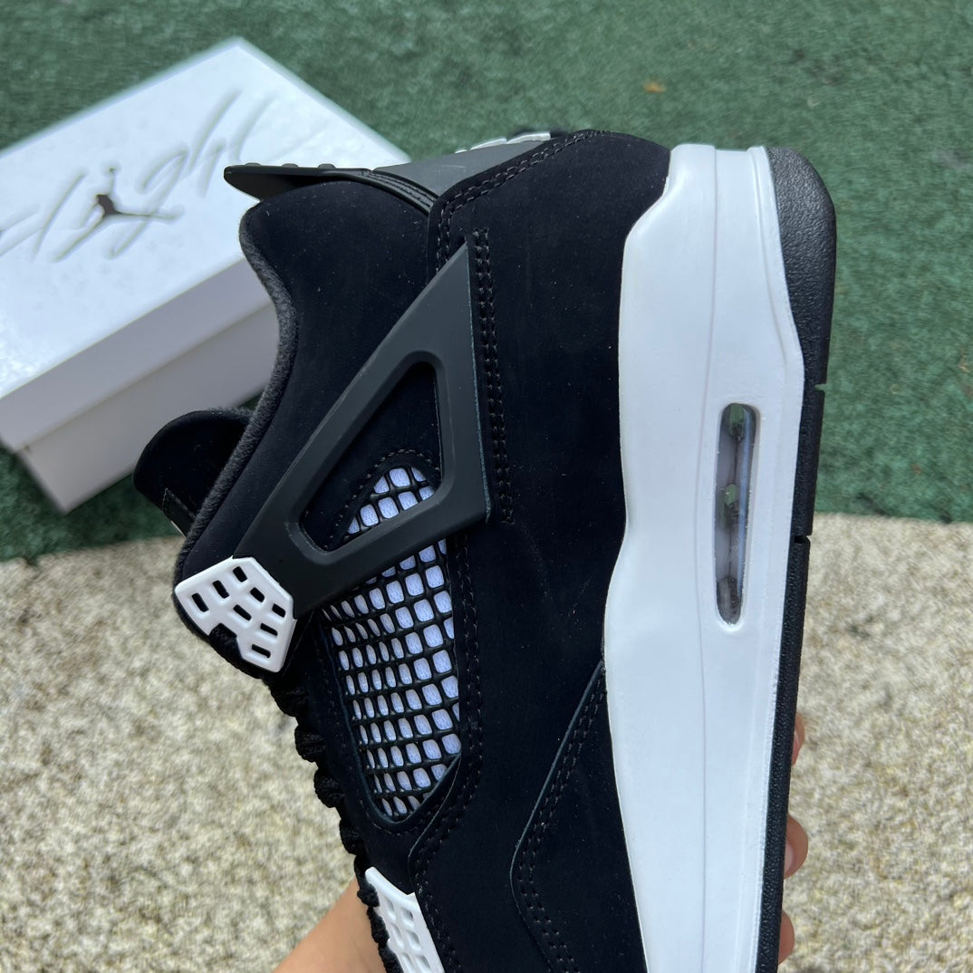Nike Air Jordan 4 Retro White Thunder sneakers with white and yellow accents, featuring a classic basketball shoe design.