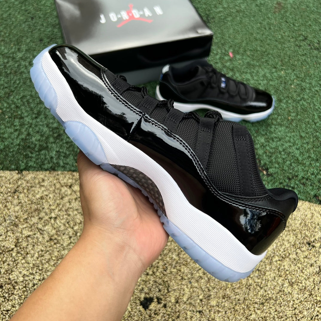 Nike Air Jordan 11 Retro Low Space Jam shoes in black and white with patent leather accents, displayed on a plain background.