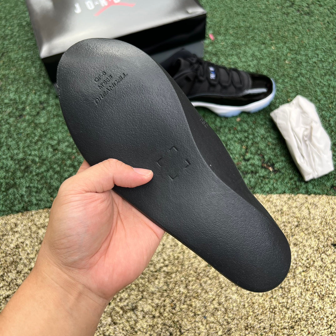 Nike Air Jordan 11 Retro Low Space Jam sneakers in black and blue with icy outsole, branded with Nike and Jordan logos.